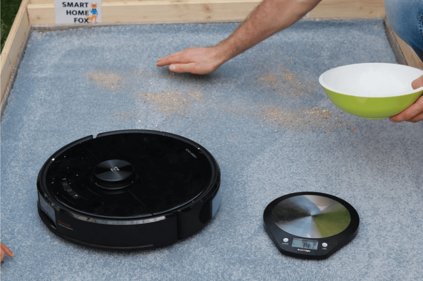 Roborock S6 MaxV during the sand suction test on a carpet.